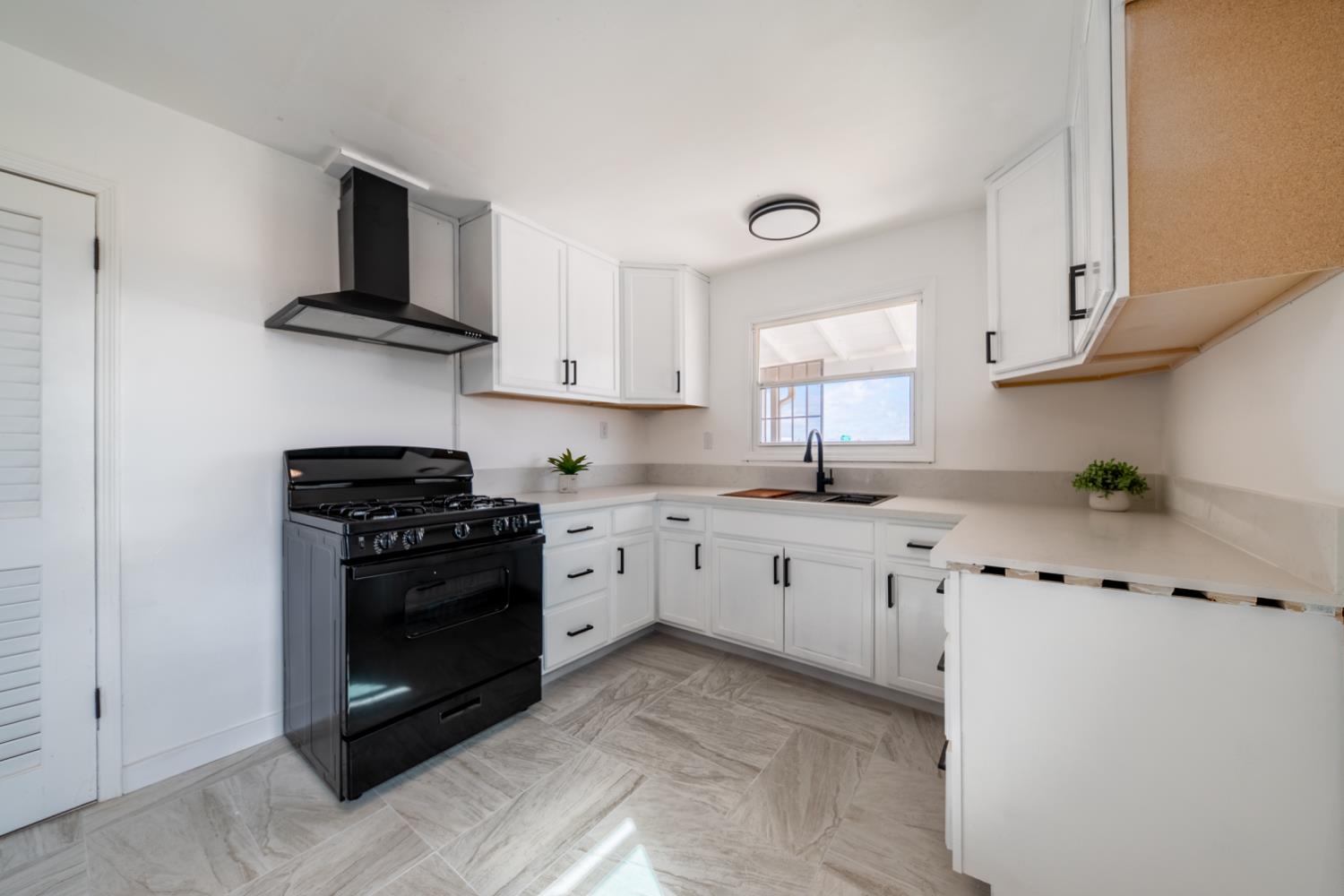 2790 Boles Street Madera, CA 93637 - Photo 9 of 19 a kitchen with stainless steel appliances a stove a sink cabinets and a window