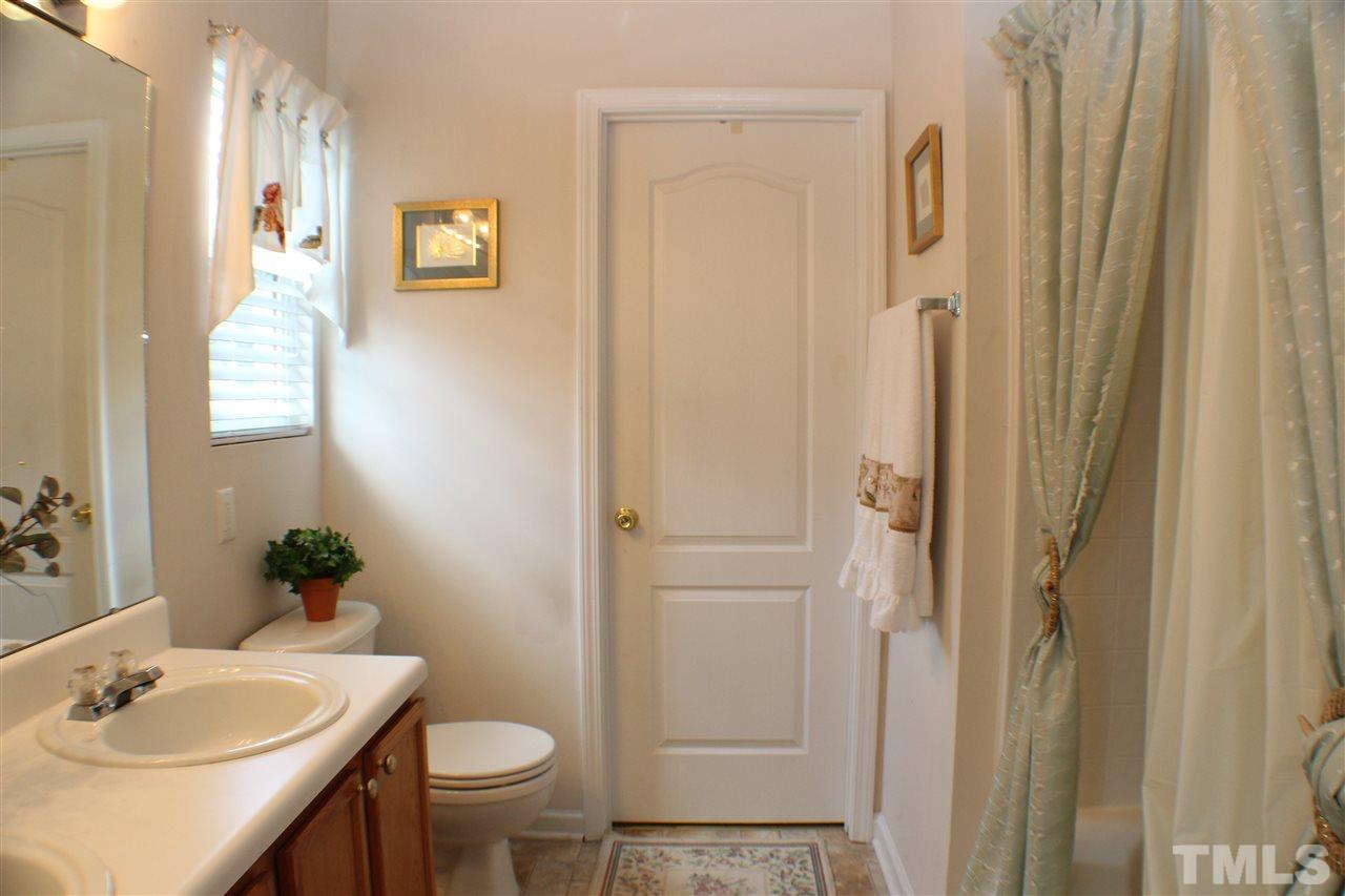 4016 Crowfield Drive Raleigh, NC 27610 - Photo 11 of 20 a bathroom with a sink a toilet and shower curtain