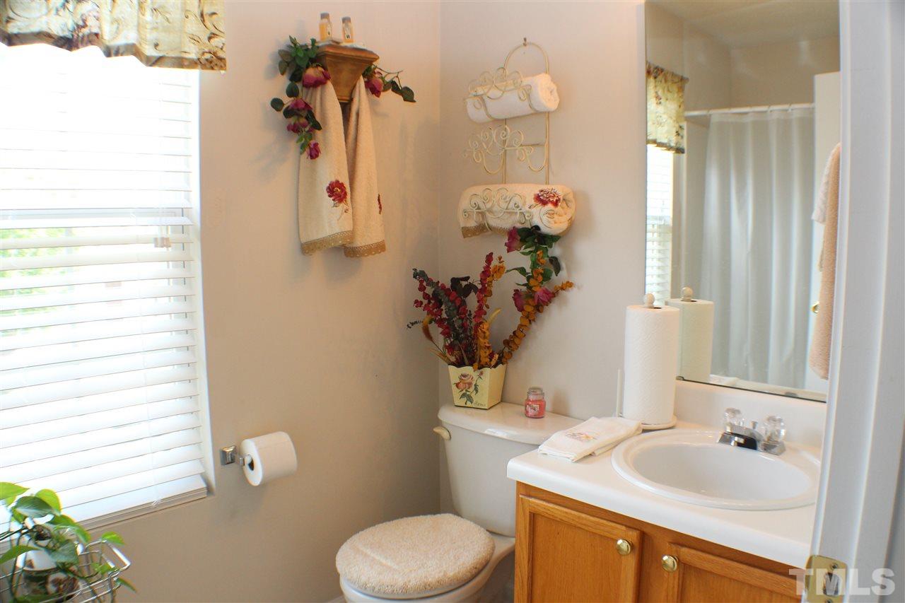 4016 Crowfield Drive Raleigh, NC 27610 - Photo 15 of 20 a bathroom with a sink a toilet and a mirror