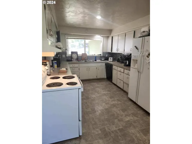a kitchen that has a sink and a stove top oven