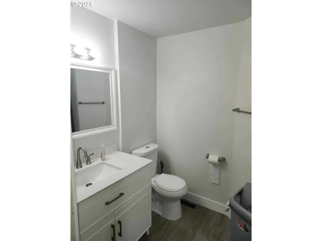 a bathroom with a granite countertop toilet a sink and a mirror