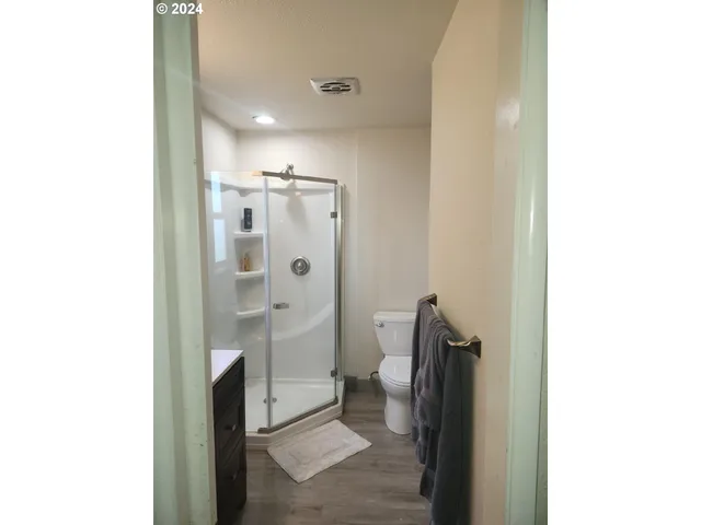 a bathroom with a granite countertop shower a toilet and a sink