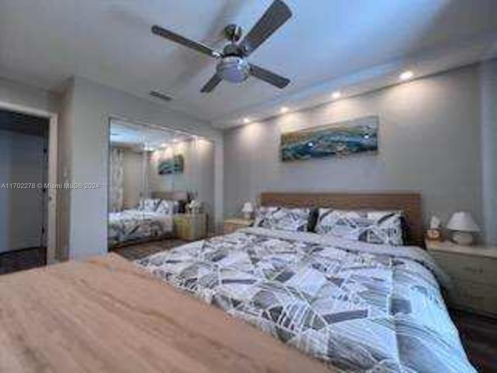 6299 La Costa Drive, Unit D Boca Raton, FL 33433 - Photo 13 of 23 a bedroom with a bed and a large mirror