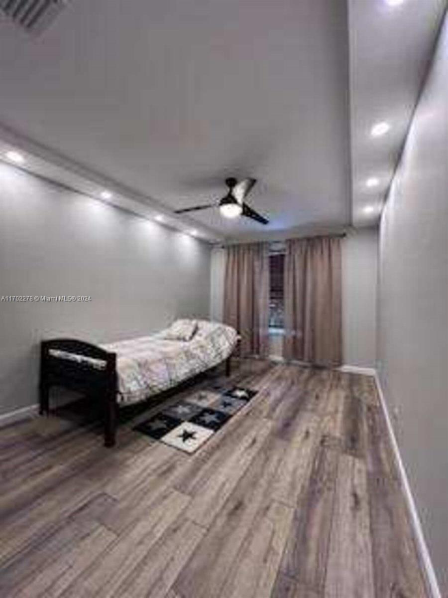 6299 La Costa Drive, Unit D Boca Raton, FL 33433 - Photo 17 of 23 a room with wooden floor and large window