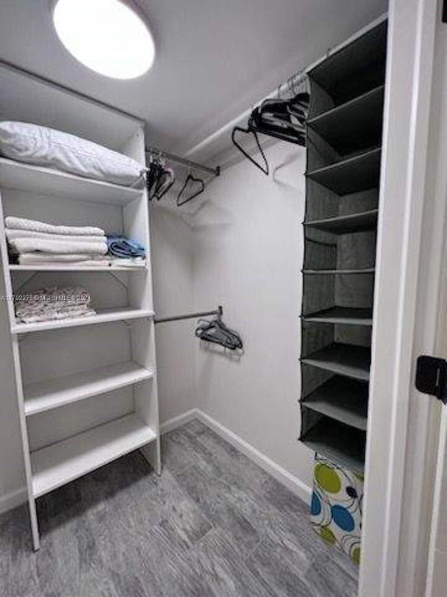 6299 La Costa Drive, Unit D Boca Raton, FL 33433 - Photo 19 of 23 a view of walk in closet with empty racks