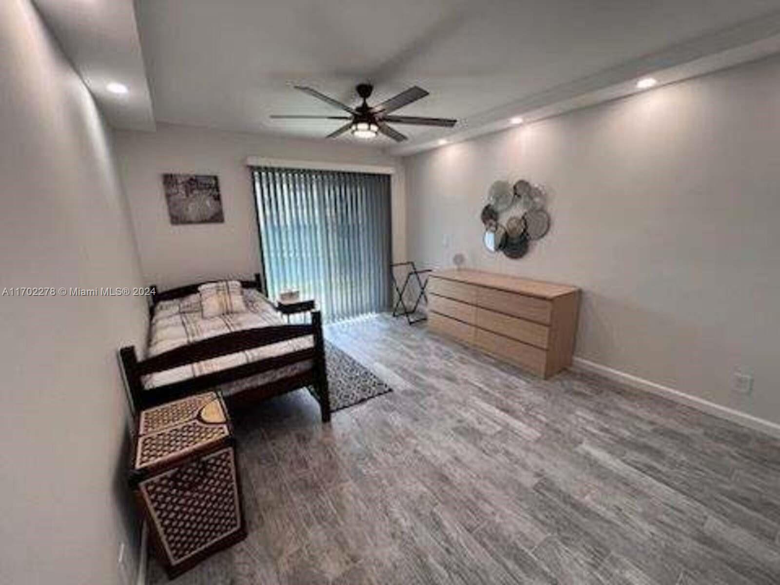 6299 La Costa Drive, Unit D Boca Raton, FL 33433 - Photo 20 of 23 a view of an empty room with wooden floor and a ceiling fan