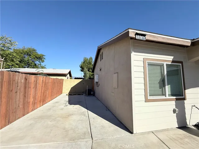 a view of wooden house with a small yard