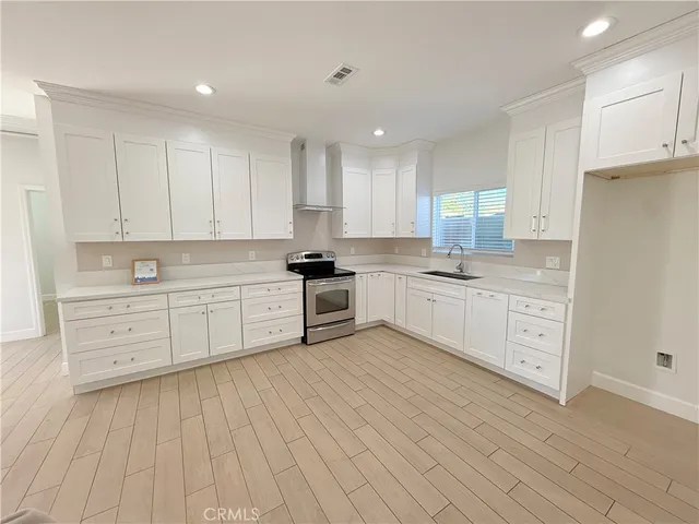 a large white kitchen with cabinets