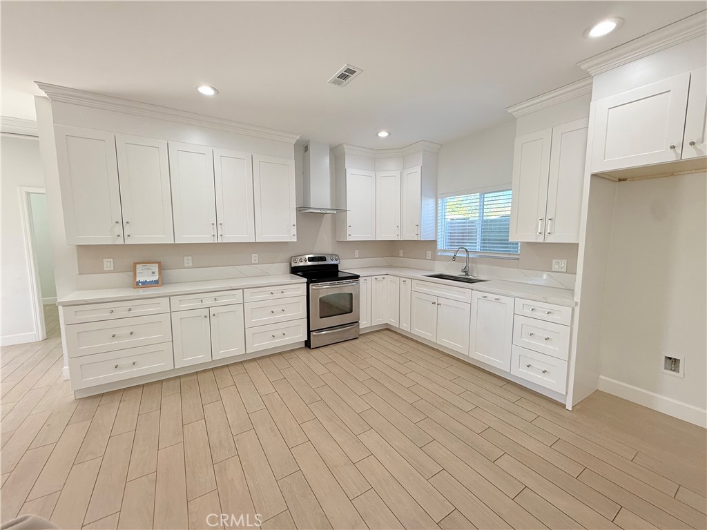125 North Orangewood Street Colton, CA 92324 - Photo 2 of 12 a large white kitchen with cabinets
