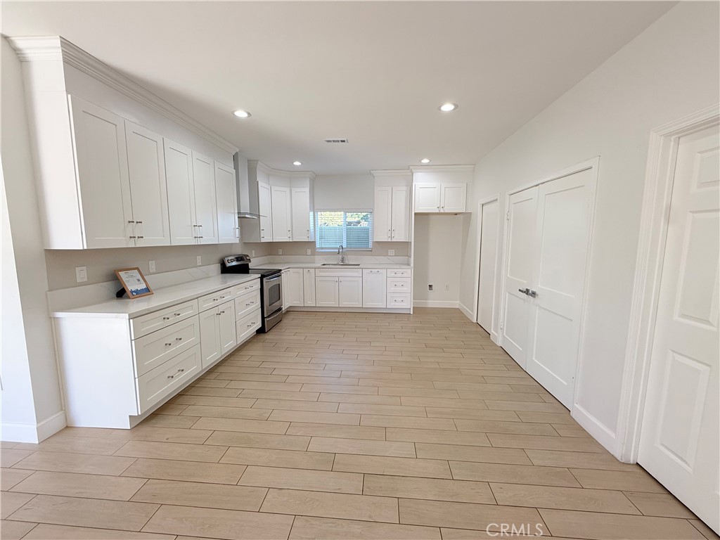 125 North Orangewood Street Colton, CA 92324 - Photo 3 of 12 a large white kitchen with white cabinets and a white stove
