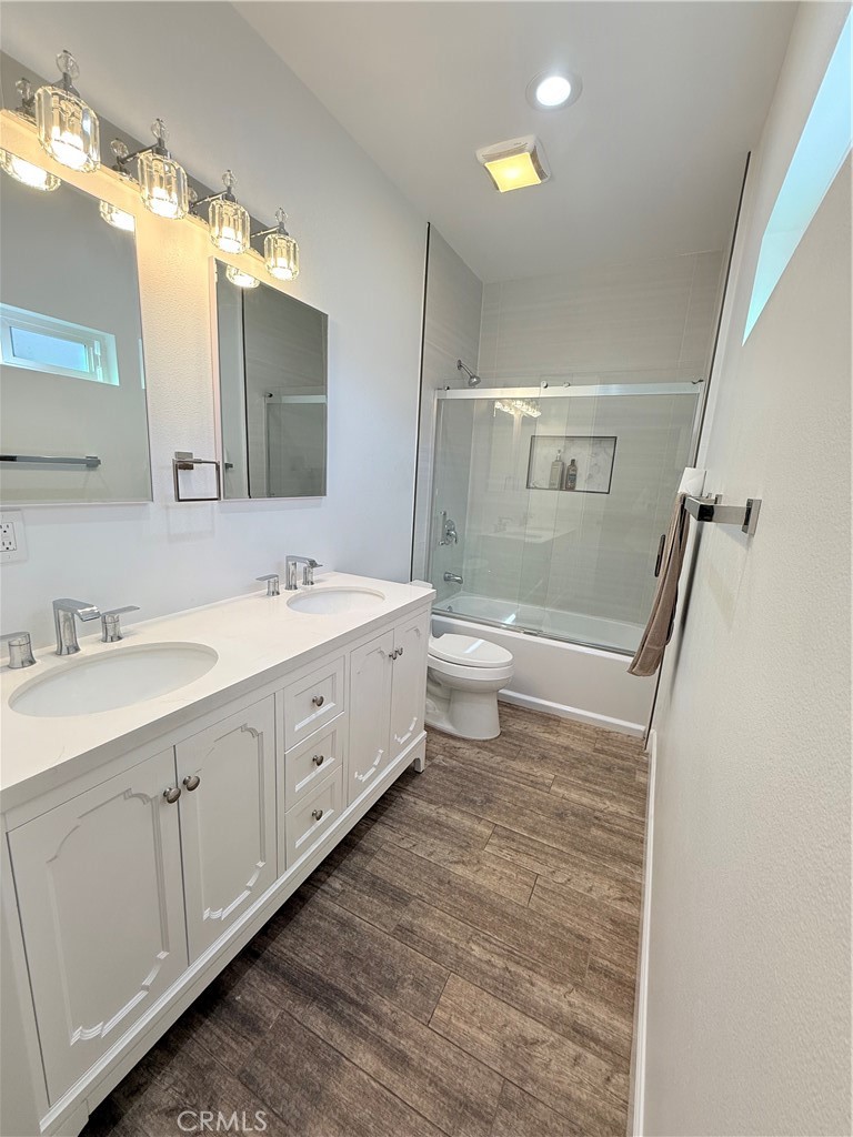 125 North Orangewood Street Colton, CA 92324 - Photo 8 of 12 a bathroom with a double vanity sink a toilet and a mirror