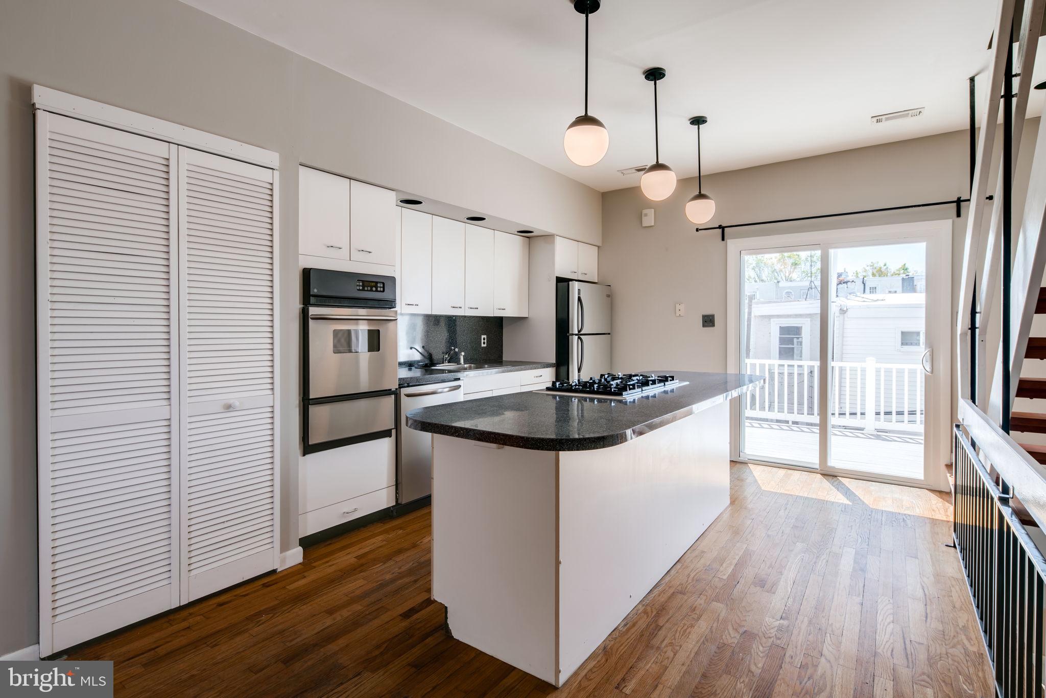 1808 Catharine Street Philadelphia, PA 19146 - Photo 1 of 30 a kitchen with stainless steel appliances granite countertop a refrigerator a sink dishwasher a stove and white countertops with wooden floor