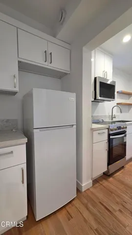 a kitchen with a refrigerator sink and stove top oven