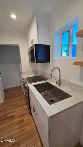 a kitchen with a sink a stove and a microwave oven
