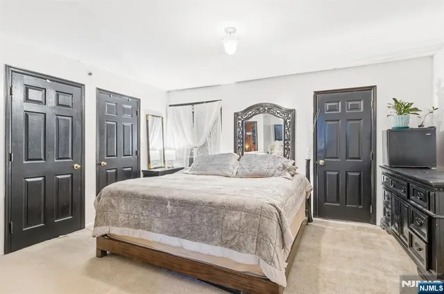 a bedroom with a bed dresser and a flat tv screen