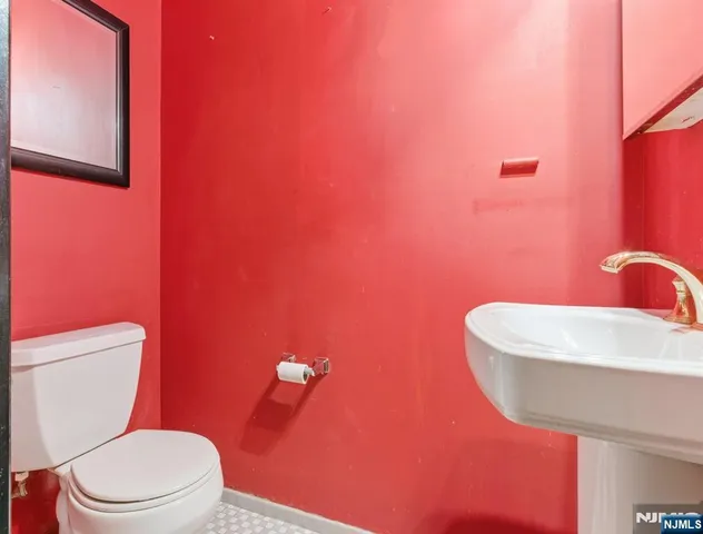 a bathroom with a toilet a sink and mirror