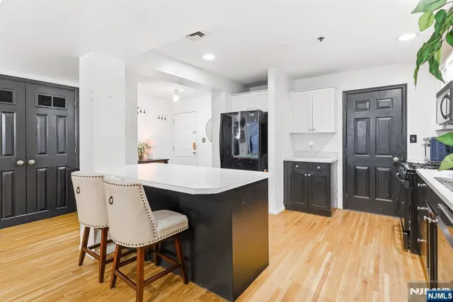 a kitchen with stainless steel appliances a dining table chairs and wooden floor