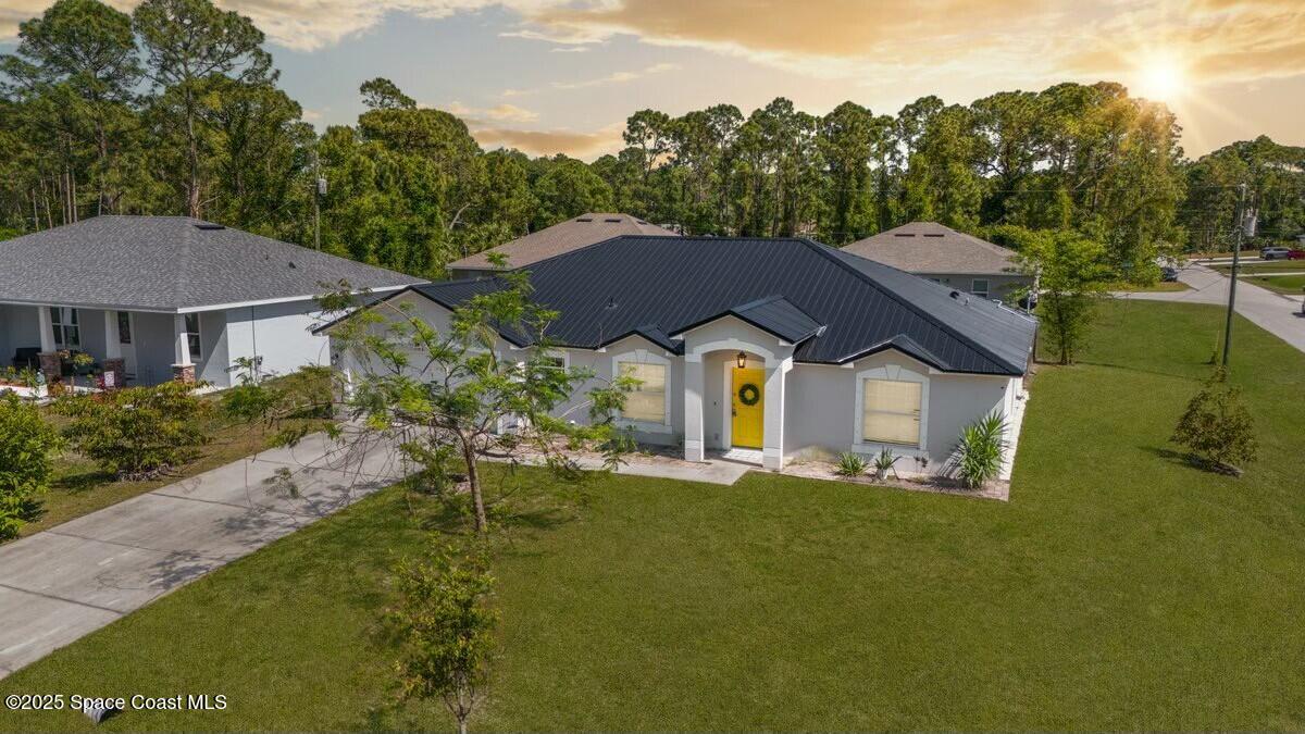 194 Saybrook Road Southwest Palm Bay, FL 32908 - Photo 1 of 35 a front view of a house with a yard and trees