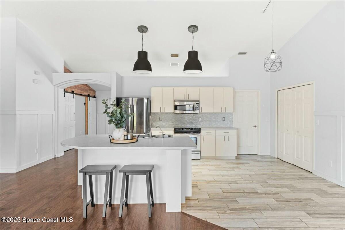 194 Saybrook Road Southwest Palm Bay, FL 32908 - Photo 12 of 35 a kitchen with stainless steel appliances kitchen island granite countertop a table chairs and a refrigerator