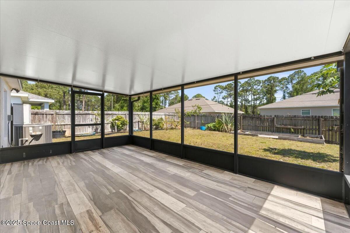 194 Saybrook Road Southwest Palm Bay, FL 32908 - Photo 20 of 35 a view of an empty room with wooden floor and a large window with an outdoor view
