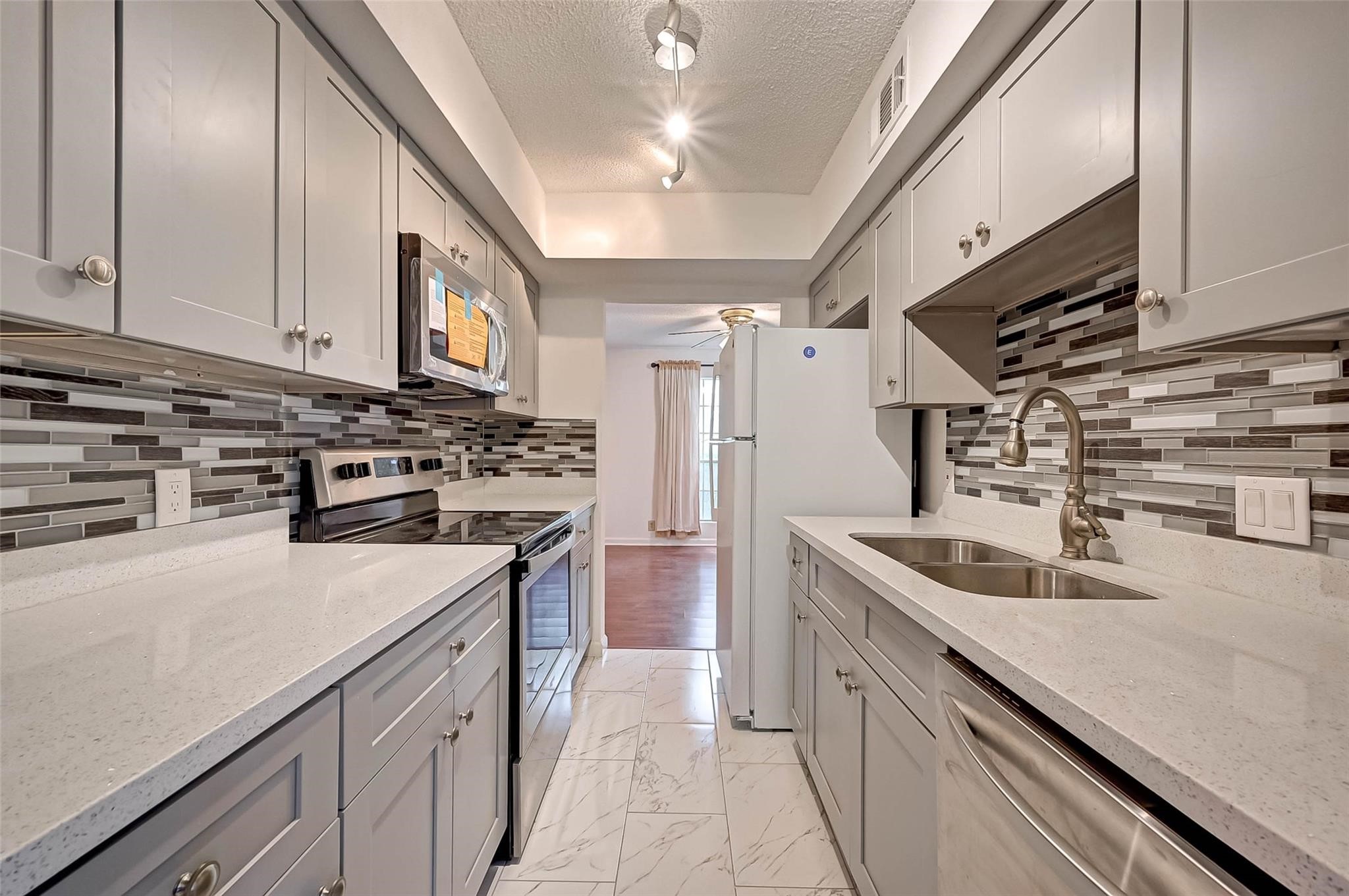 8101 Amelia Road, Unit 206 Houston, TX 77055 - Photo 16 of 32 a kitchen with stainless steel appliances granite countertop a sink stove and refrigerator