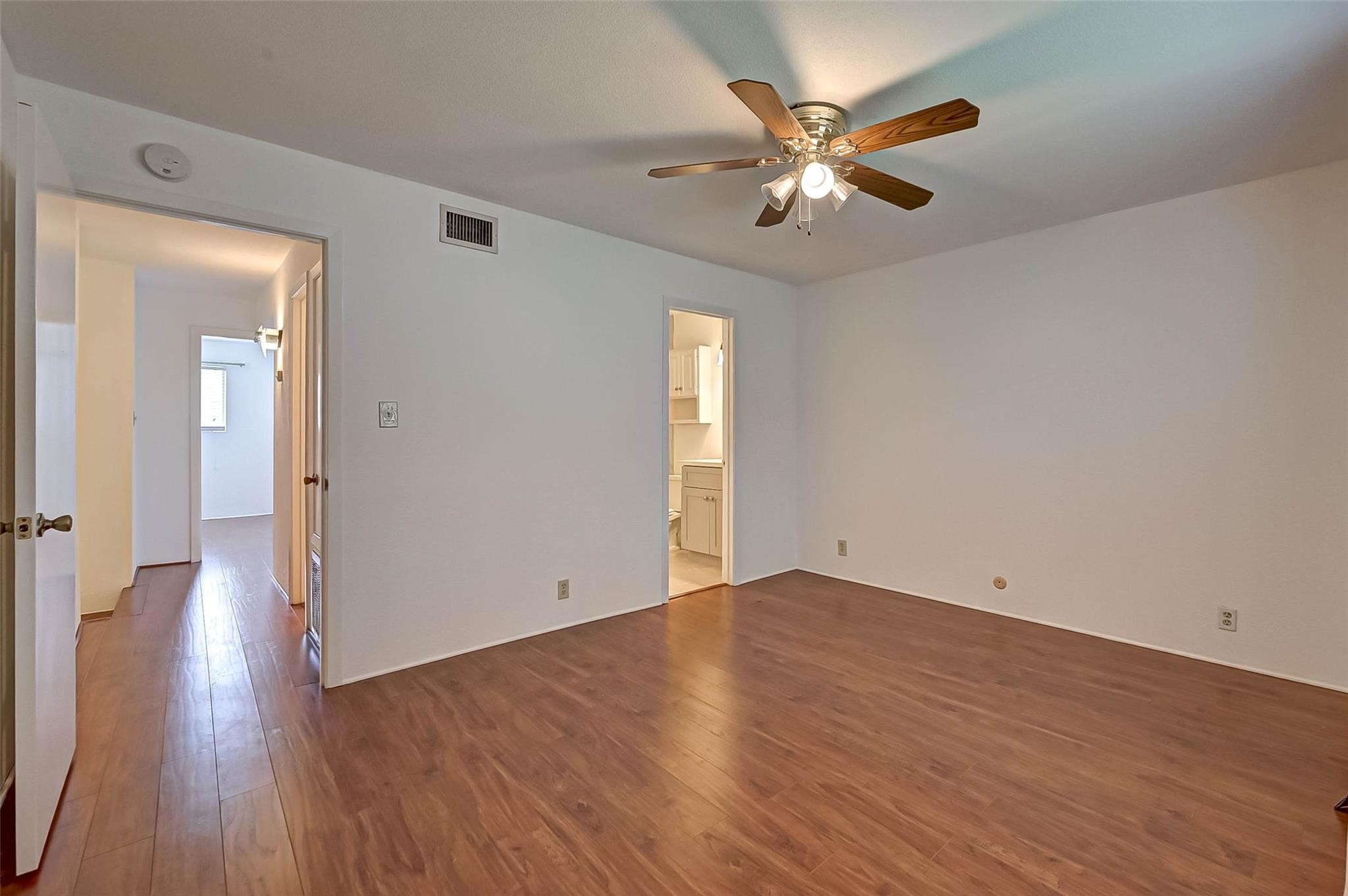 8101 Amelia Road, Unit 206 Houston, TX 77055 - Photo 24 of 32 an empty room with wooden floor and a ceiling fan