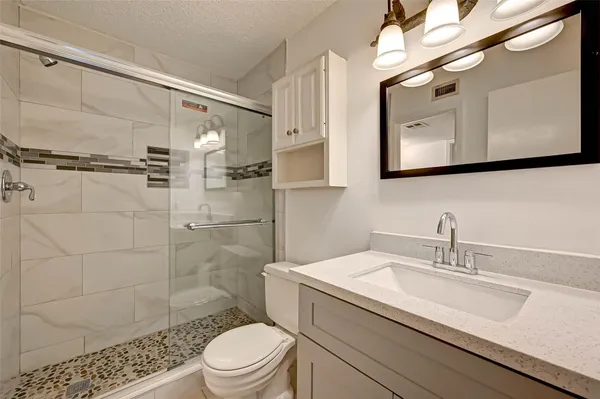 a bathroom with a sink a toilet and shower