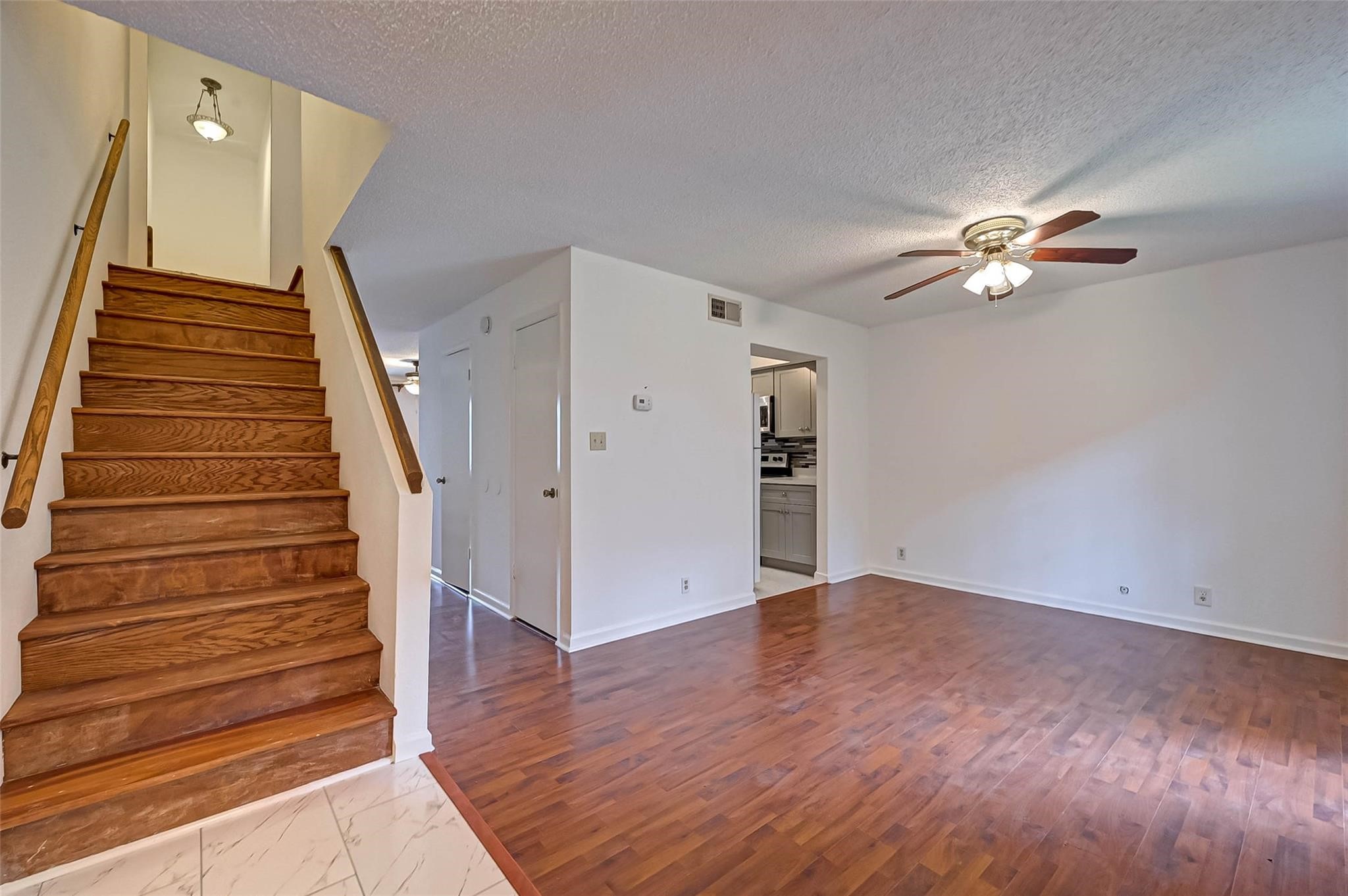8101 Amelia Road, Unit 206 Houston, TX 77055 - Photo 5 of 32 a view of an empty room with wooden floor and a ceiling fan