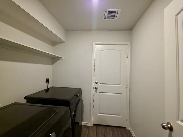 a view of a room with wooden floor and chandelier