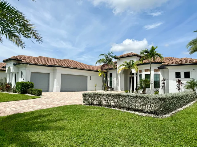 a front view of a house with a garden and trees