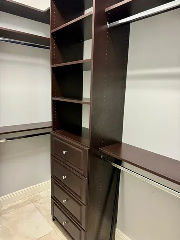a view of walk in closet with empty racks