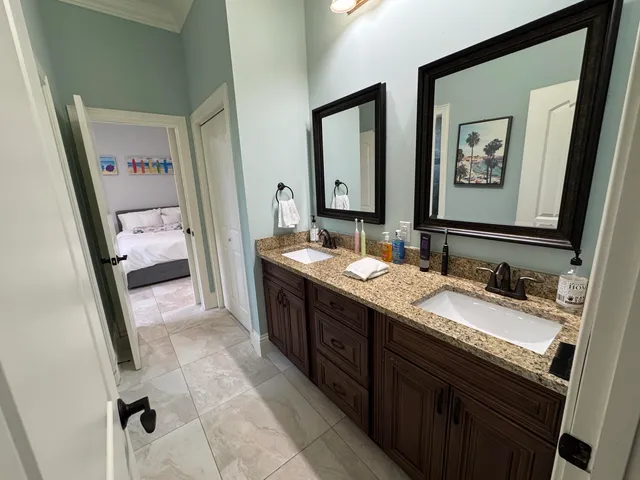 a bathroom with a granite countertop double vanity sink and a mirror