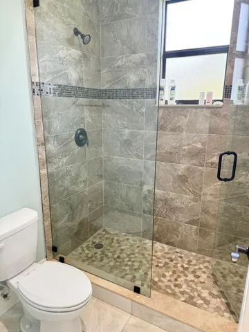 a bathroom with a toilet and a shower