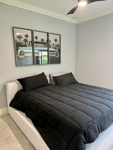 a bedroom with a bed a painting on the wall and window