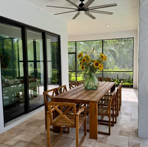 a view of a backyard with table and chairs potted plants