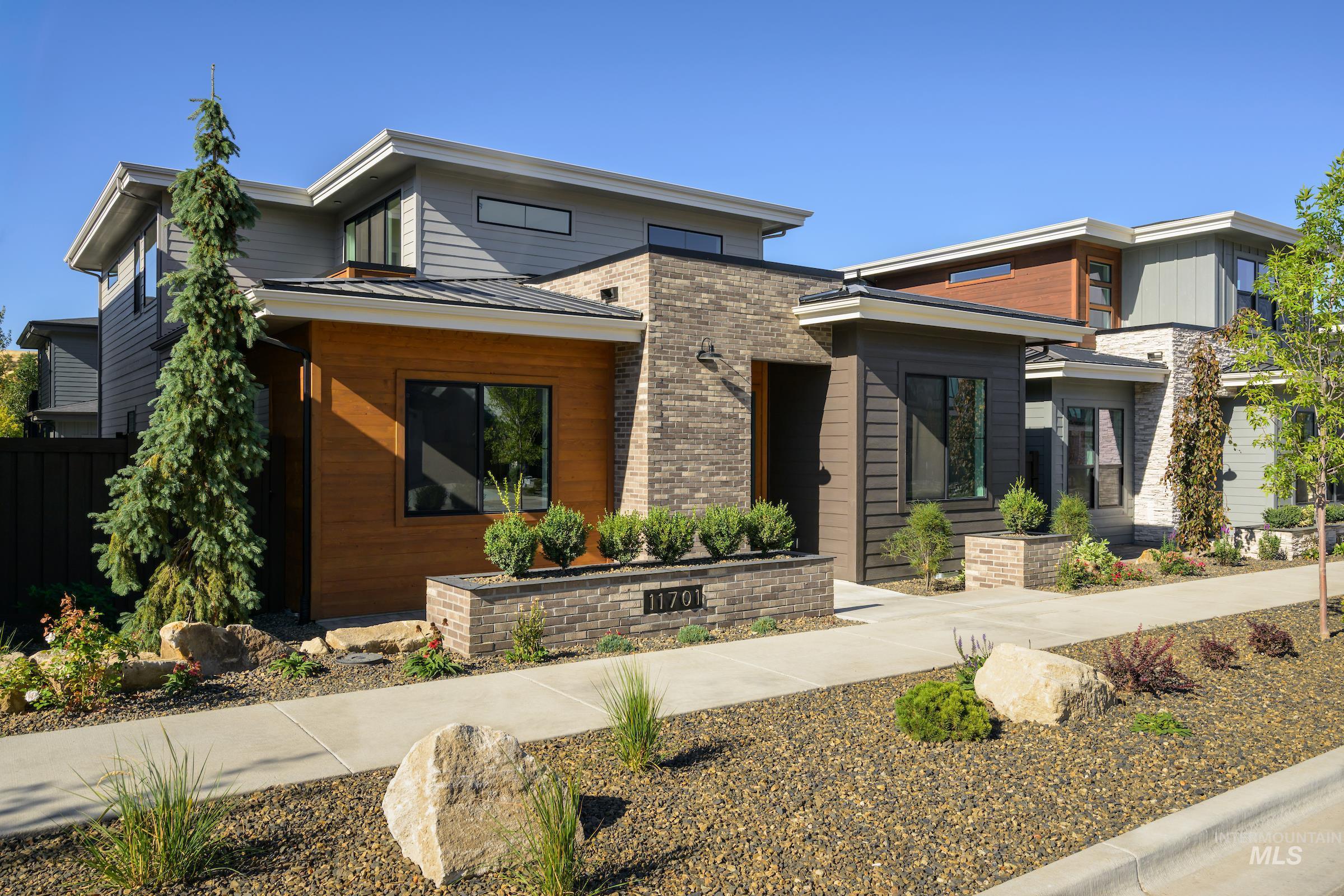 Contemporary house with a standing seam roof, a metal roof, and brick siding