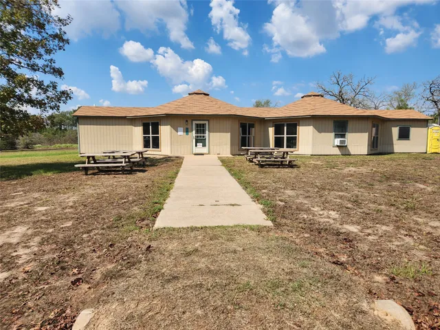 a front view of a house with a yard and trees