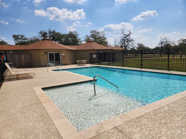 a view of a house with pool and a yard