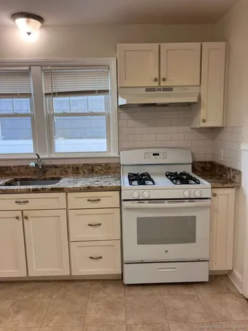 a stove top oven sitting inside of a kitchen
