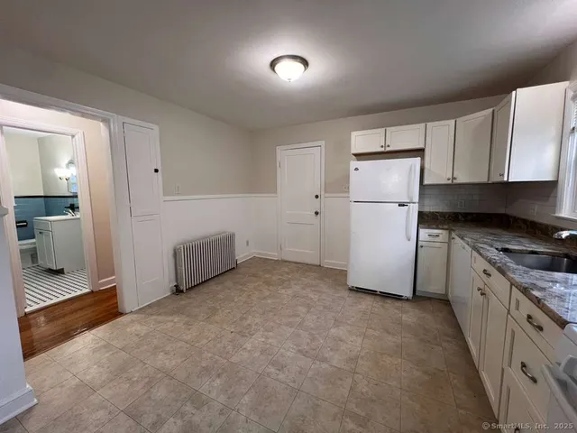 a kitchen with refrigerator and cabinets