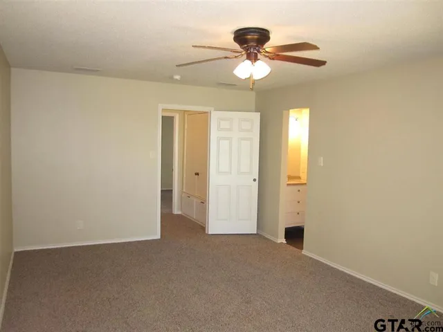 an empty room with a chandelier fan and a chandelier fan