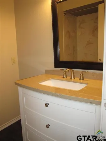 a bathroom with a granite countertop sink and a mirror