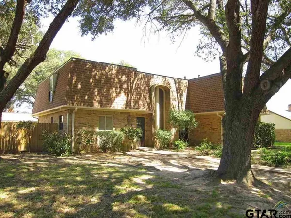 a view of a house with a tree in the background