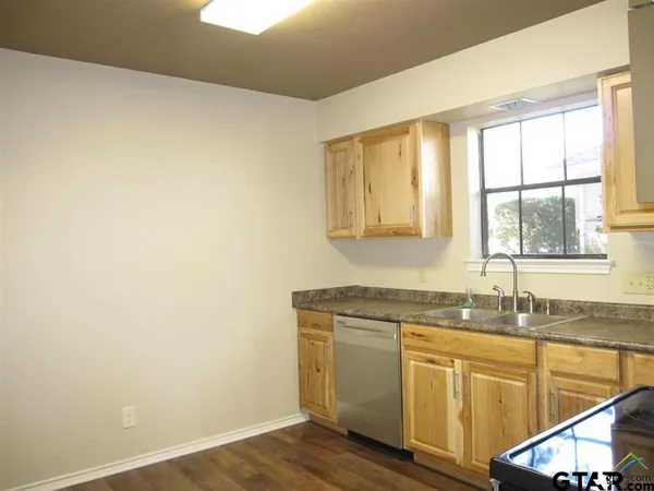 a kitchen with granite countertop white cabinets and a sink