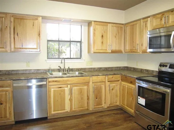 a kitchen with stainless steel appliances granite countertop a stove a sink and a microwave