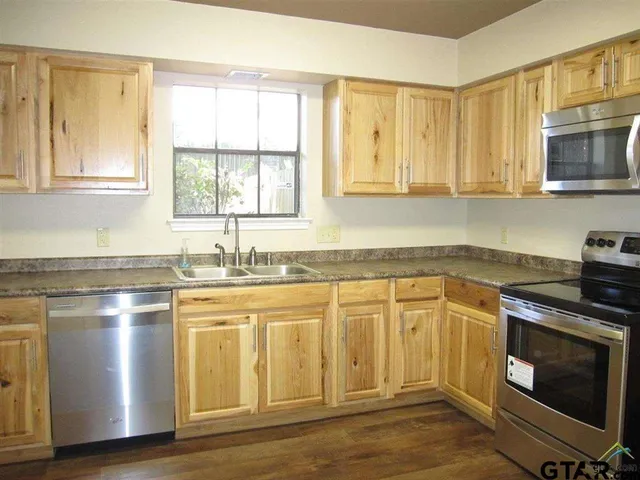 a kitchen with stainless steel appliances granite countertop a stove a sink and a microwave