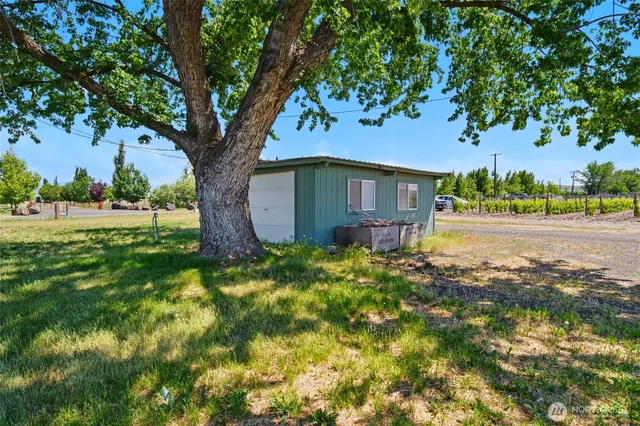 a house is sitting in middle od the grass