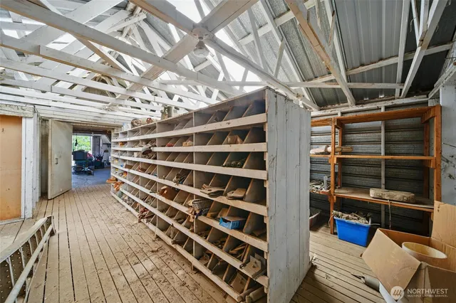 a view of an empty room with wooden floor and windows