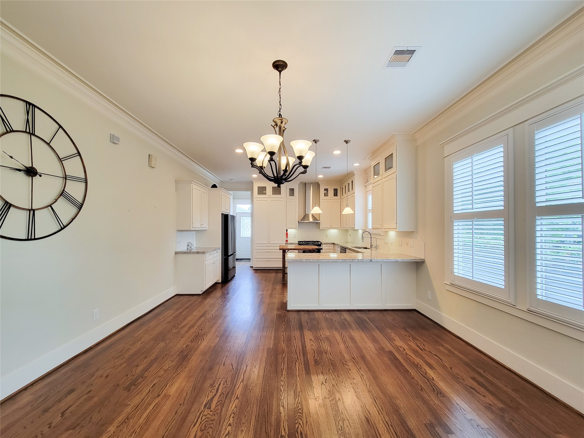 1140 West Cottage Street Houston, TX 77009 - Photo 11 of 37 a large white kitchen with a large window a chandelier and stainless steel appliances