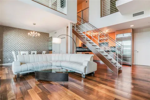 a living room with couches and a rug with wooden floor